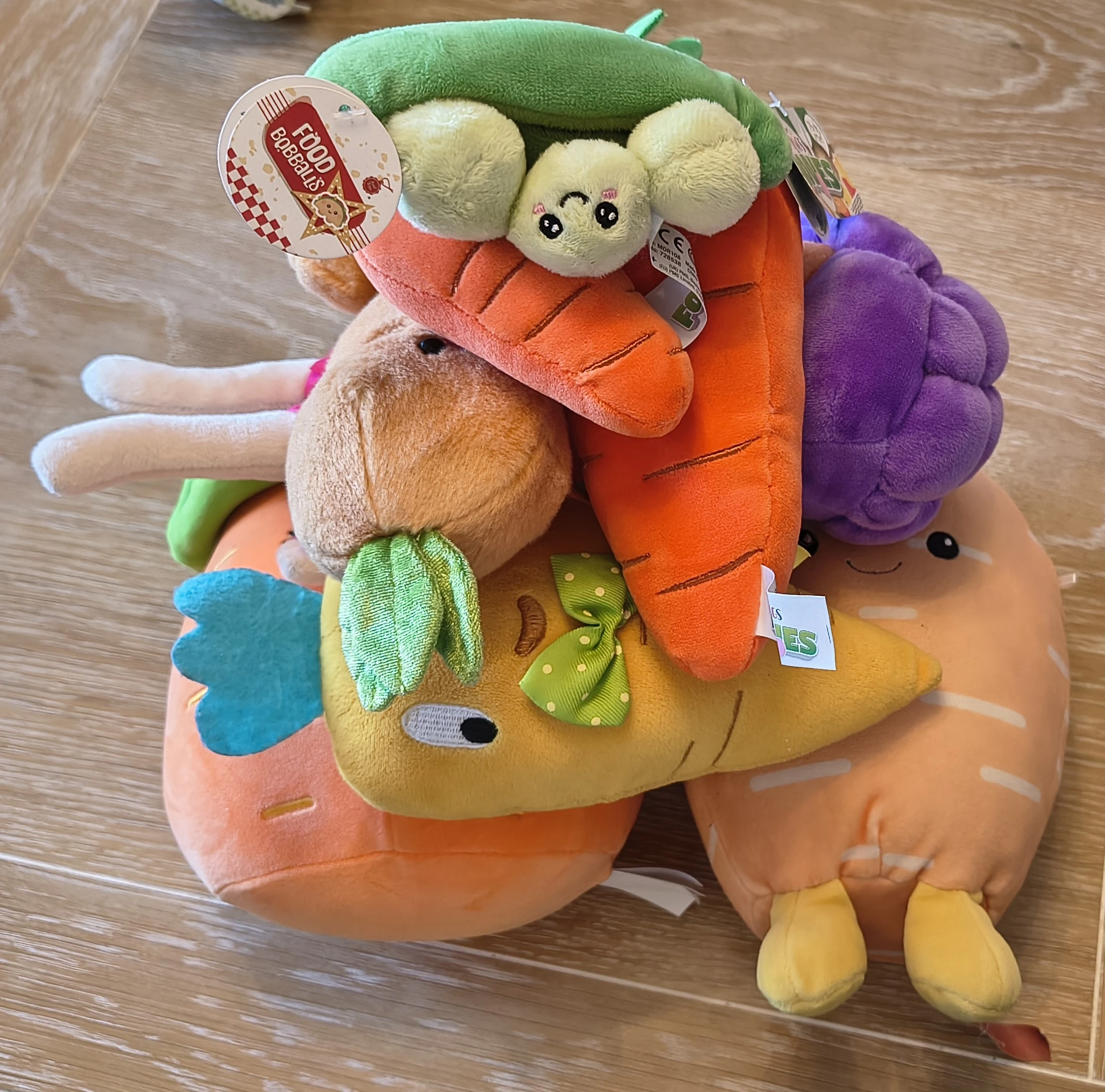 A pile of cuddly plush carrots with a pod of cuddly peas on top