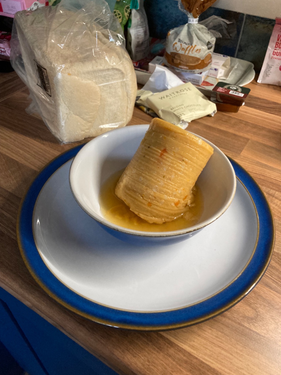 A can of soup emptied into a bowl. However, the soup is thick and has held the shape of the can.